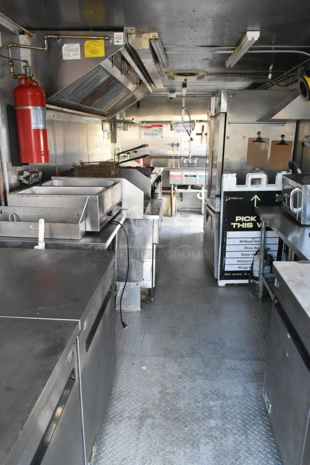 Fully equipped food trailer with Pyrochem hood, fire suppression, Arctic Air coolers, Wells range, Pitco fryer, and prep tables.