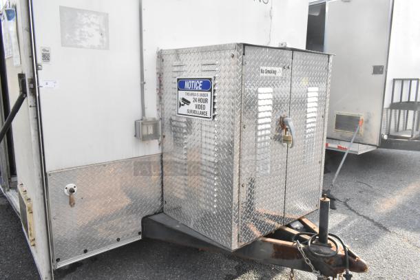 Brand new food trailer with diamond plate exterior, heavy-duty hitch, and "24 Hour Video Surveillance" sign. Secure, mobile kitchen setup.