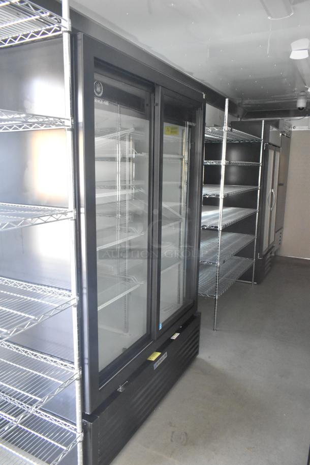 Brand new food trailer interior with commercial-grade refrigeration units, metal shelving, and stainless steel fixtures.