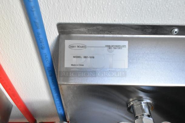 Close-up of a Serv-Ware sink tag, model BS1-1818, made in China, featuring commercial-grade plumbing pipes.