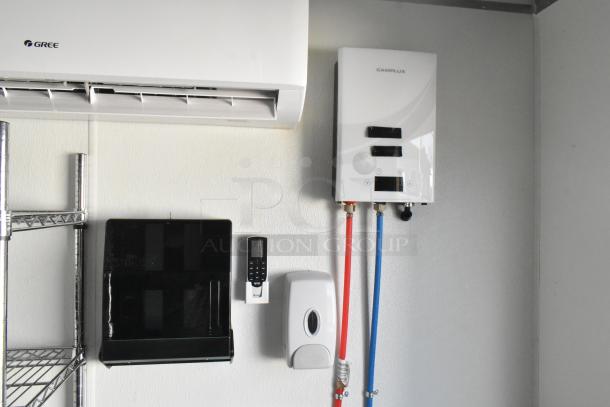 Fully equipped food trailer interior with Camplux tankless water heater, Gree air conditioner, and wall-mounted dispenser.