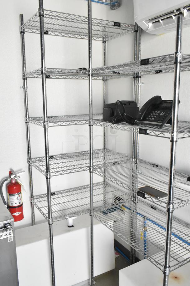 Stainless steel wire shelving in a food trailer, with a phone and fire extinguisher. Clean, organized setup.