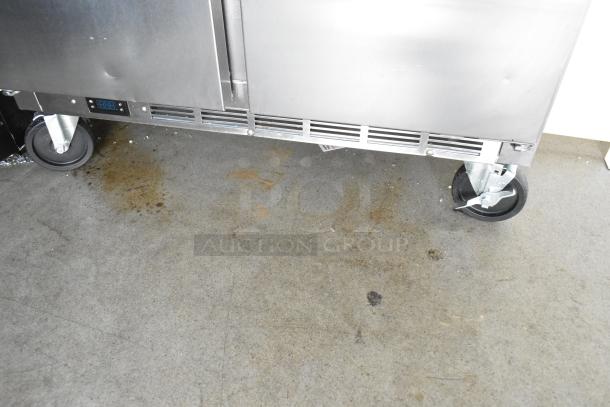 Stainless steel food trailer with commercial fridge on casters, digital temperature display. Used condition, some surface stains visible.