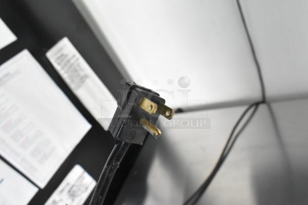 Electrical plug and documentation inside a fully outfitted food trailer with commercial-grade equipment.