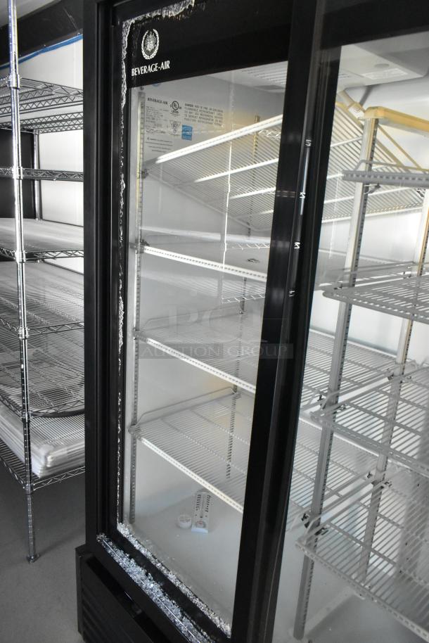 Inside view of a fully outfitted mobile kitchen trailer featuring a Beverage Air reach-in cooler and wire shelving units.