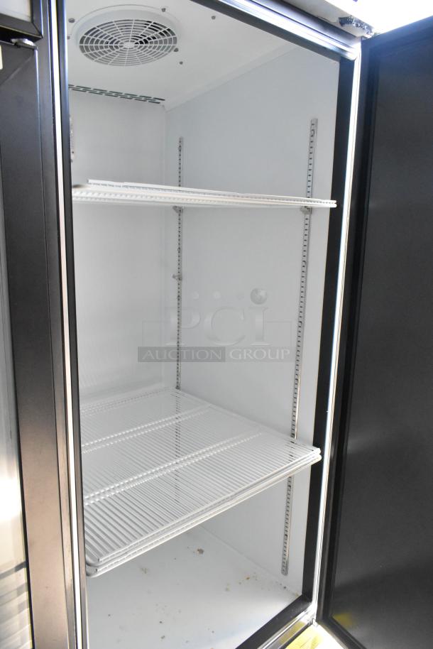 Empty commercial-grade beverage cooler interior with wire shelving in a mobile food trailer.