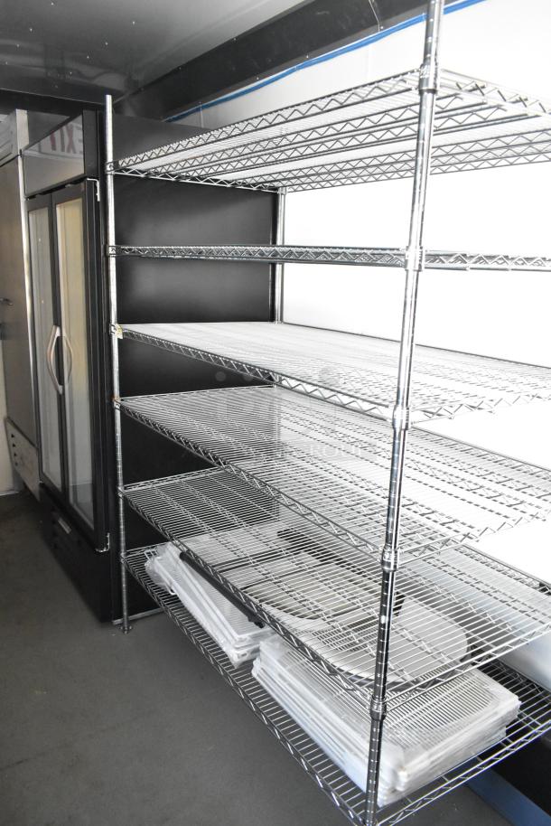 Unbranded food trailer interior with wire shelving and Beverage Air merchandiser, ideal for mobile kitchens.