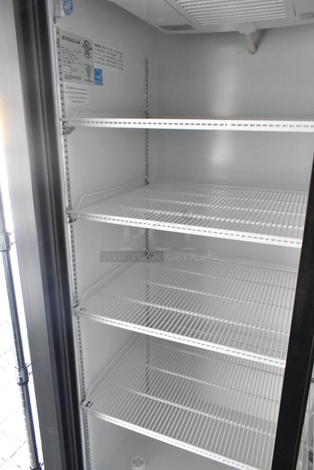 Interior view of Beverage Air reach-in cooler with four wire shelves, shown inside a fully outfitted mobile kitchen trailer.