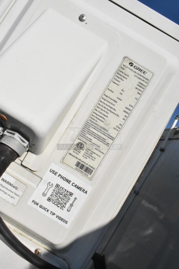 Gree air conditioner unit on a food trailer, featuring technical specifications label and QR code for tip videos.