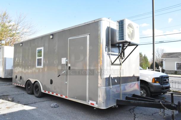 Brand new unbranded food trailer, fully equipped with commercial-grade kitchen appliances, gray exterior, ready for use.