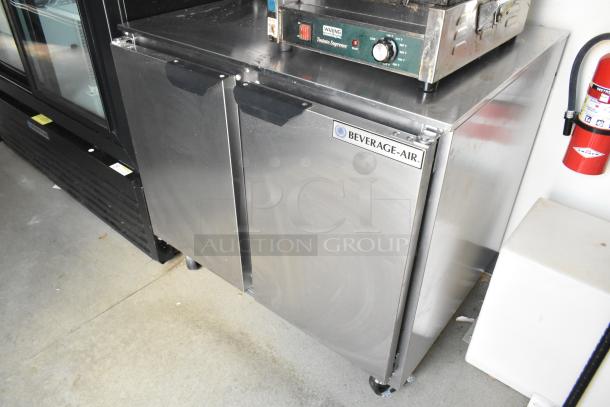 Fully equipped stainless steel Beverage Air reach-in cooler in food trailer, featuring Waring Panini Press on top.