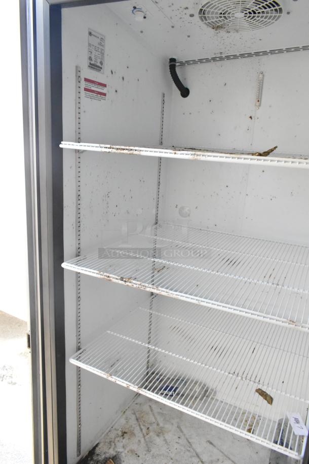 Interior view of a used Beverage Air reach-in cooler with wire shelves. Visible dirt and wear indicate the need for cleaning.