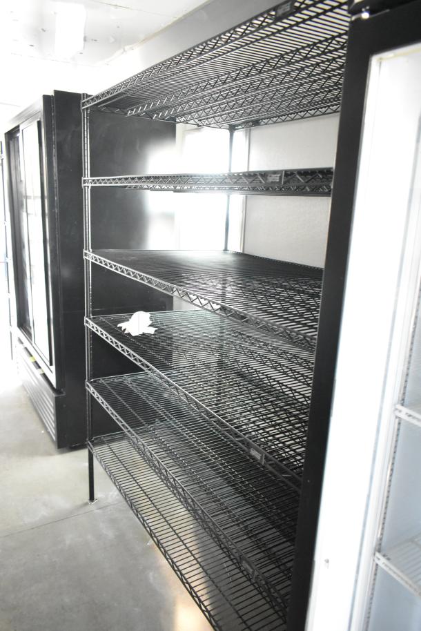 Empty wire shelving inside a fully outfitted unbranded food trailer, showcasing ample storage space for a mobile kitchen setup.