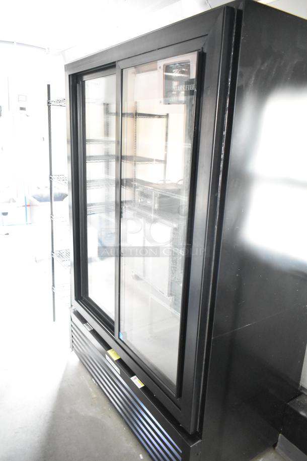 Black commercial double-door cooler with glass front, metal shelves, and air vents below, ideal for food trailer setup.