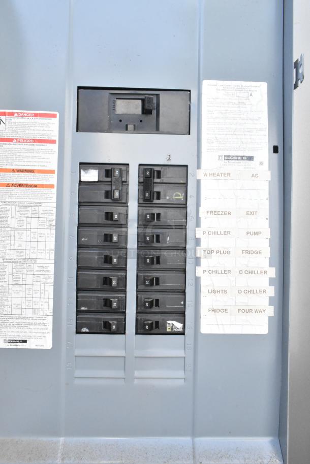Electrical panel inside food trailer featuring labeled circuit breakers for appliances like freezer, fridge, and A/C.