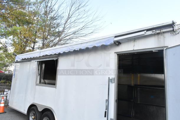 Brand new unbranded food trailer with awning, equipped with Coleman's Mack ventilation system and shelves, ready for outfitting.