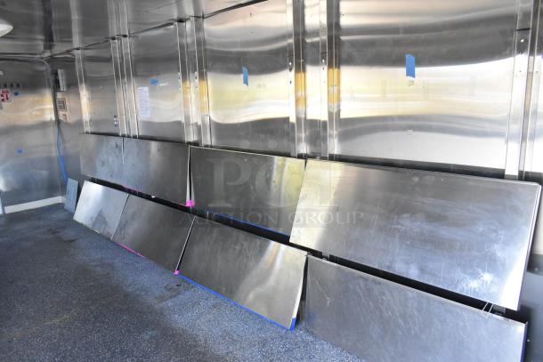 Brand new unbranded food trailer interior, awaiting equipment. Features Coleman's Mack Ventilation, shelves, and wire shelving.
