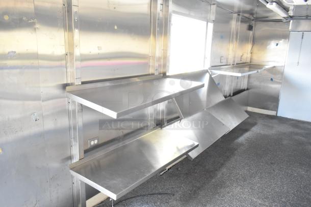 Brand new unbranded food trailer interior with Coleman's Mack Ventilation System, stainless steel shelving, ready for equipment.