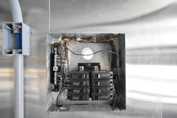 Electrical panel inside brand new unbranded food trailer, showing wiring and circuit breakers, ready for equipment installation.
