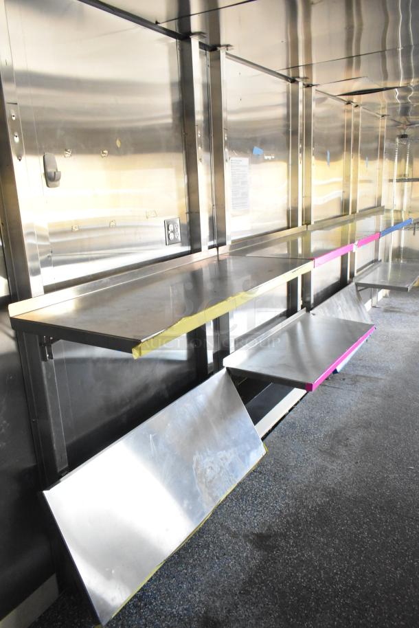 Brand new unbranded food trailer interior, featuring Coleman's Mack Ventilation System and stainless steel shelving.