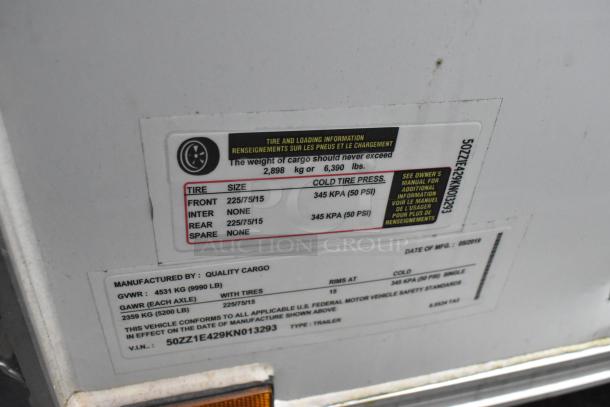 Label on unbranded 24' Quality Cargo food trailer showing tire and loading specifications, GVWR, and manufacture date.