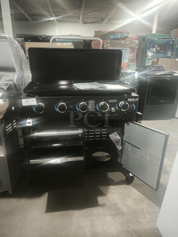 Brand new Pit Boss PB5BGD2 gas griddle, 5 burners, cabinet, black finish, back-lit knobs, open storage doors, warehouse setting.