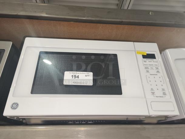 BRAND NEW Scratch and Dent GE 1.1 Cu. Ft. Countertop Microwave Oven, Model GCST11N1WWW, with control panel and label.