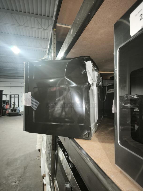 BRAND NEW GE 1.7 cu ft Over-the-Range Microwave, Model JVM6175SK6SS. Minor dents visible on the side.