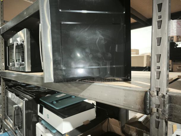 Brand new GE 1.6 cu ft Over-the-Range Microwave Oven, model PVM9005SJ8SS, scratch and dent, on warehouse shelf.