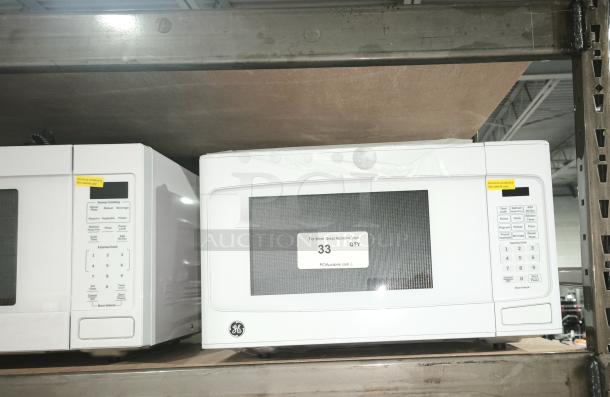 BRAND NEW GE 1.1 Cu. Ft. Countertop Microwave Model GCST11N1WWW, scratch-and-dent condition, white, on shelf.