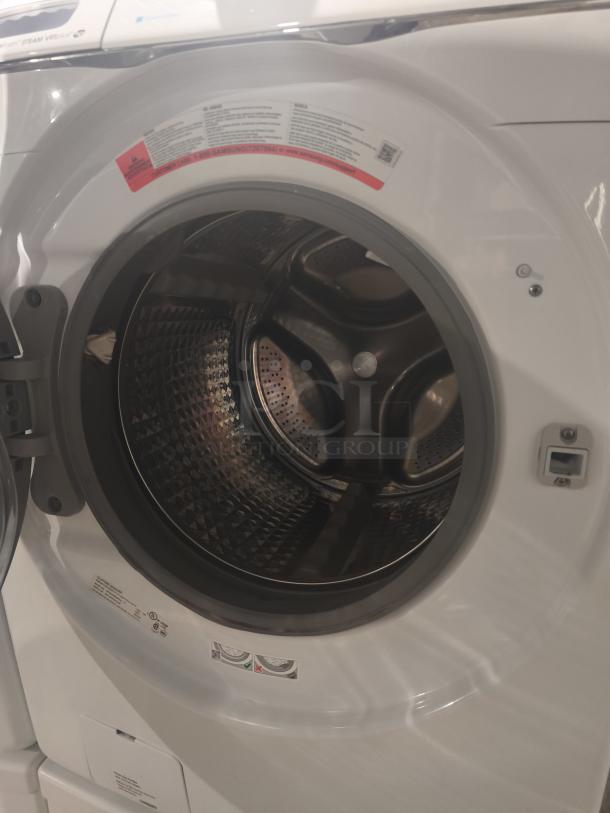 Samsung 4.5 cu ft Smart Front-Load Washer WF45H6300AW/A2 in excellent condition. Front view with door open showing drum interior. Tags showcase usage and care instructions.