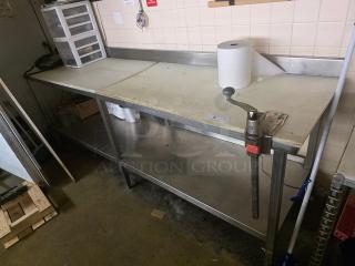 Stainless steel cutting board table with integrated can opener, used condition. Features under-shelf storage and backsplash.