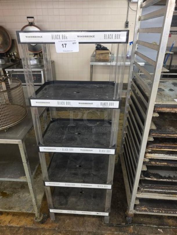 5-tier rolling shelf with "Woodbridge Black Box" branding, transparent sides, and black shelves. Used condition.