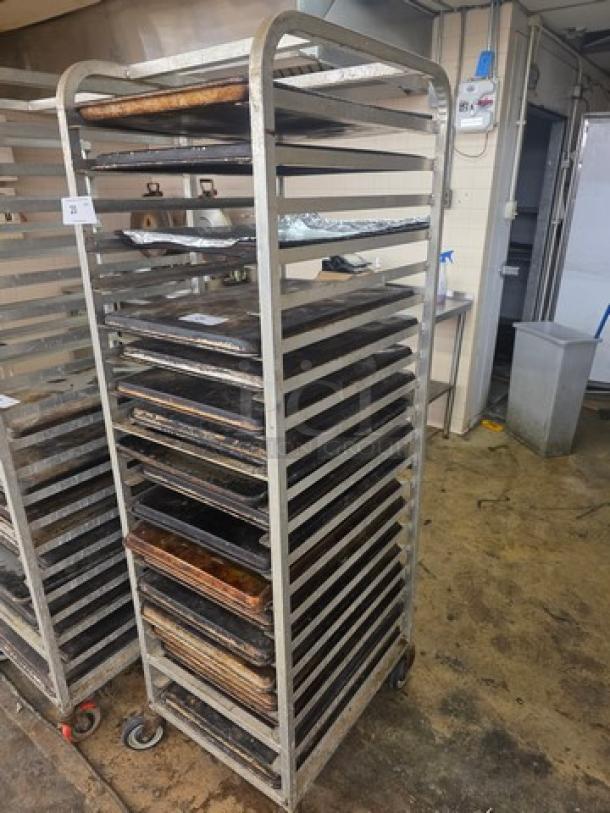Sheet pan rack on casters, holds multiple pans. Sturdy metal frame, used condition. Ideal for commercial kitchens.