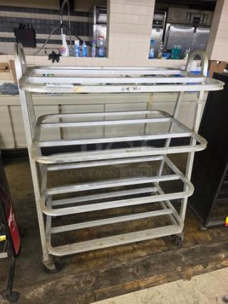 Industrial lug dolly with four shelves, metal frame, swivel casters. Used condition, suitable for heavy-duty transport.