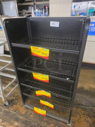 Black metal shelving unit with five wire shelves, item tag "24," sale labels indicating $3.21. Used condition.