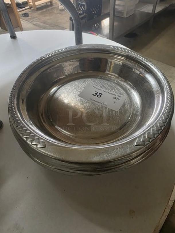 Lot of 8 stainless steel food pans, round with decorative edges, item labeled "38", in good condition, ideal for serving.