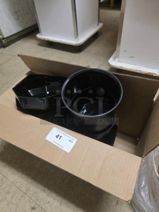 Cardboard box containing several black plastic containers, varying shapes, label marked "41, QTY".