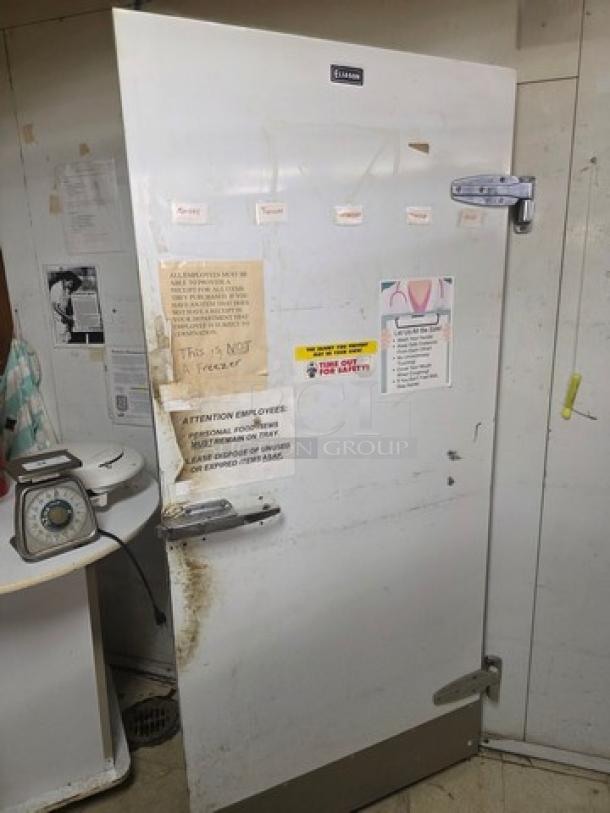 Walk-in cooler door with hardware, includes various labels and notes. Moderate wear. Buyer responsible for removal.