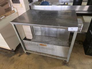 Stainless steel cart with two shelves, sturdy frame, on wheels. Moderate wear visible; perfect for industrial use. Label marked "71".
