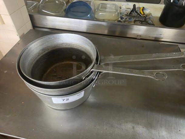 Lot of 3 metal sauce pans with long handles, showing signs of wear. Label marked "72" indicates auction item number.