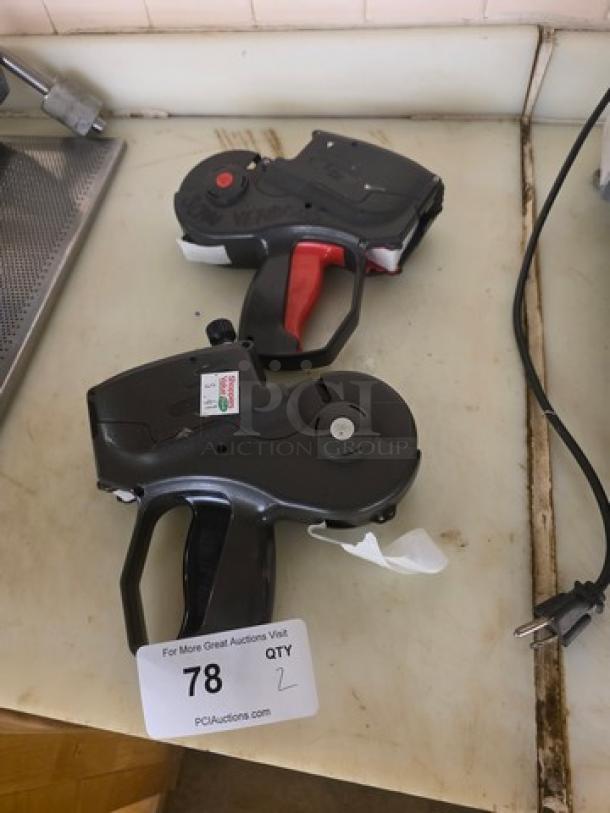 Lot of 2 Monarch 1151 label guns in used condition, featuring ergonomic handles. Auction tag shows "QTY 2, 78".