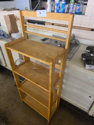 Wooden shelf with four tiers, natural finish, moderate wear. Auction tag numbered 79. Ideal for storage or display.