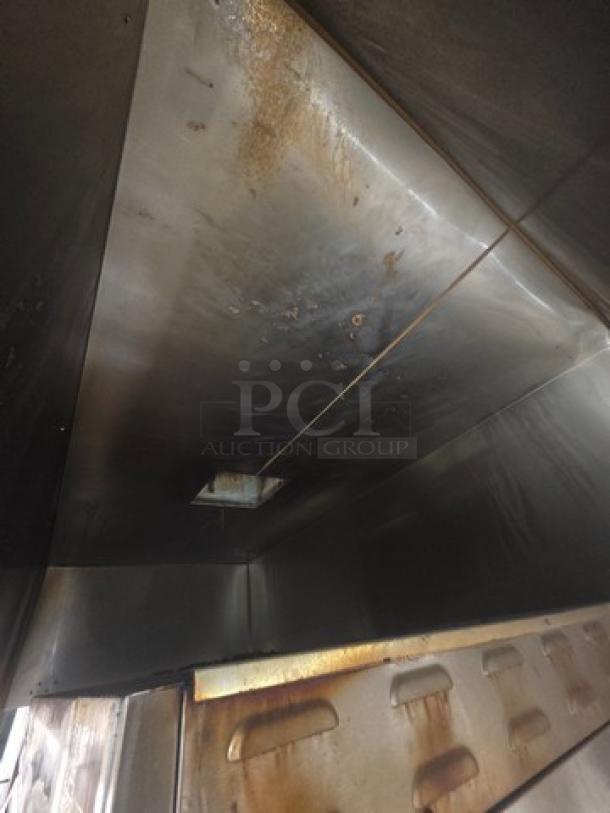 Commercial exhaust hood with visible signs of use and discoloration. Buyer must remove. Durable metal construction.