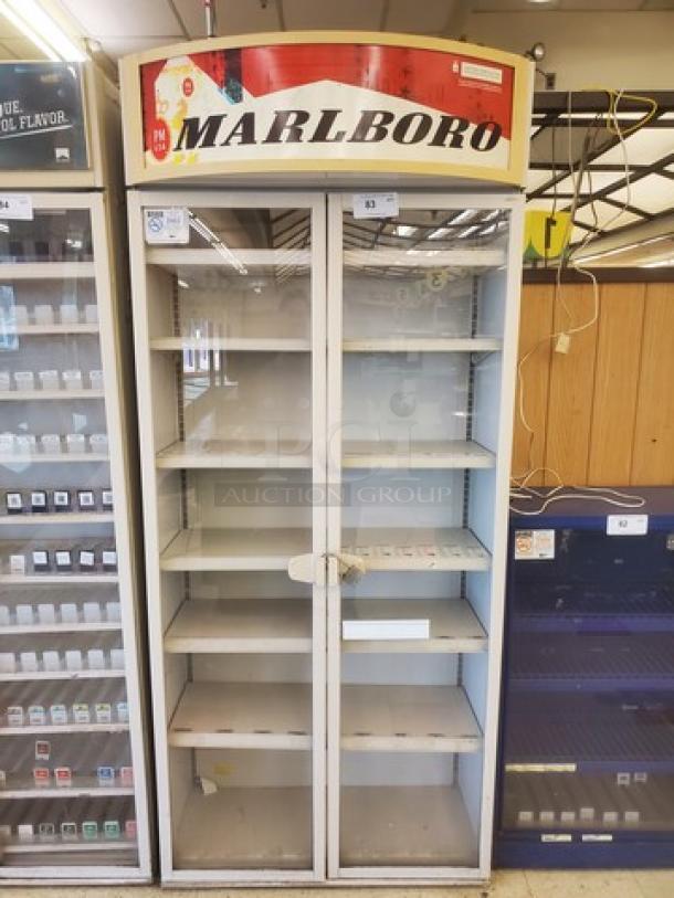 Marlboro cigarette display case with six shelves, glass doors, and Marlboro branding on the top. Visible wear suggests used condition.