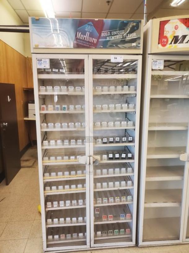 Vintage cigarette display case with glass doors, Marlboro branding, five shelves, and visible cigarette pack slots. Good condition.