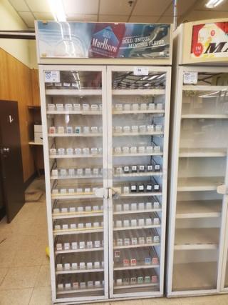 Vintage cigarette display case with glass doors, Marlboro branding, five shelves, and visible cigarette pack slots. Good condition.