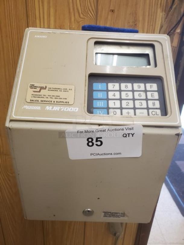 Amano MJR-7000 Calculating Time Clock, keypad, small display, model marked on front. Moderate wear, auction label attached.