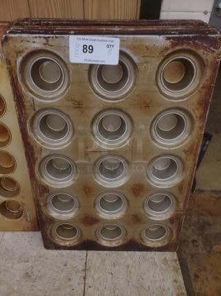 Lot of 8 muffin/cupcake baking pans with 12 slots each. Used condition, visible wear. Auction label indicates item number 89.
