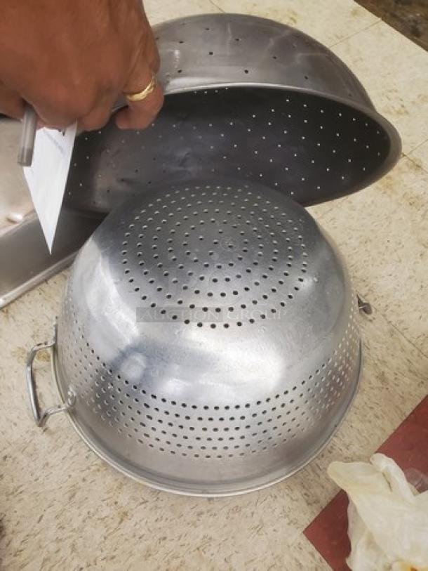 Lot of miscellaneous perforated metal food pans and bowls, used condition, various sizes, ideal for commercial kitchen use.